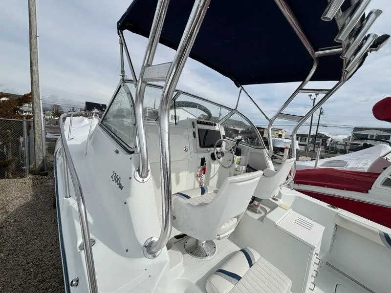 Slide: The Image of 2005 Polar 2300 boat with canopy, steering wheel, and seating, docked outdoors. - 16