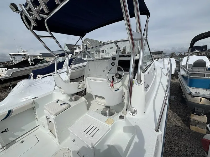 Slide: The Image of 2005 Polar 2300 boat with white interior and steering console, docked outdoors. - 17