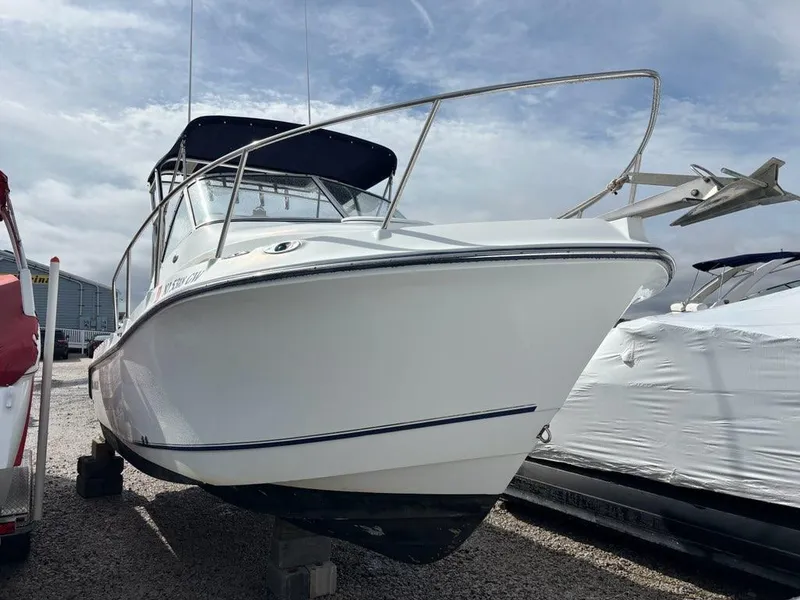 Slide: The Image of 2005 Polar 2300 boat on display, white hull, parked outdoors under cloudy sky. - 4