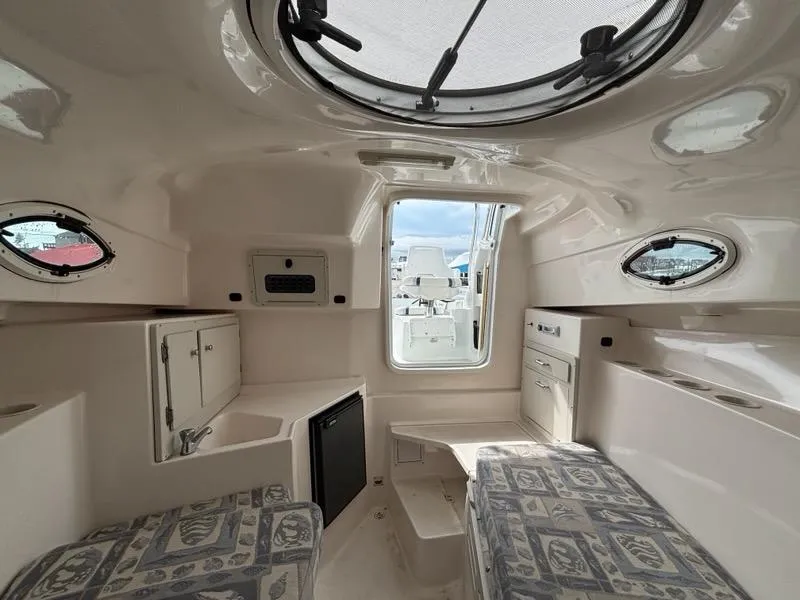 Slide: The Image of Interior of 2005 Polar 2300 boat cabin with seating, storage, and portholes. - 6