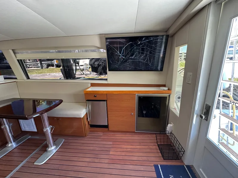Slide: The Image of Interior of 1985 Bertram 46 Convertible yacht with seating, table, and TV. - 18