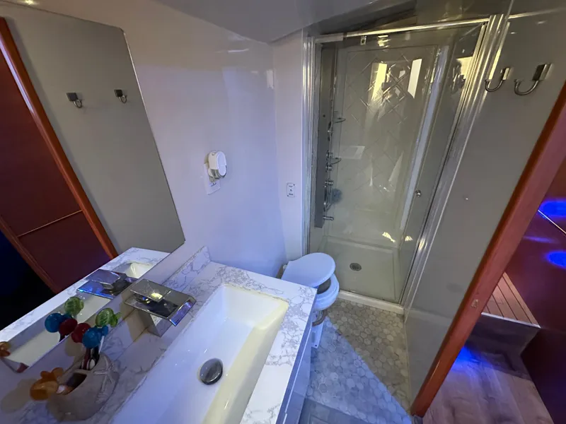 Slide: The Image of Luxurious bathroom in a 1985 Bertram 46 Convertible yacht, featuring a modern sink and shower. - 22