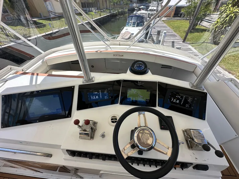 Slide: The Image of 1985 Bertram 46 Convertible yacht helm with modern navigation instruments and steering wheel. - 29