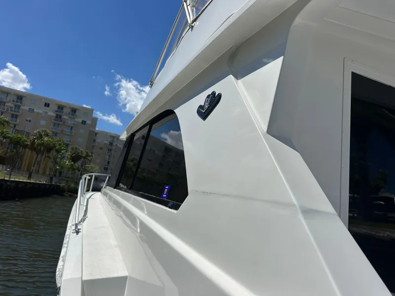 Slide: The Image of 1985 Bertram 46 Convertible yacht, sleek white exterior, docked near waterfront buildings. - 31