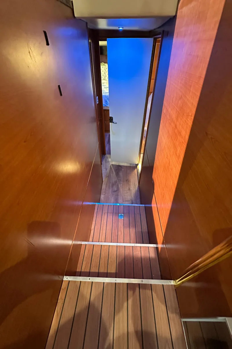 Slide: The Image of 1985 Bertram 46 Convertible interior hallway with wooden flooring and ambient lighting. - 37