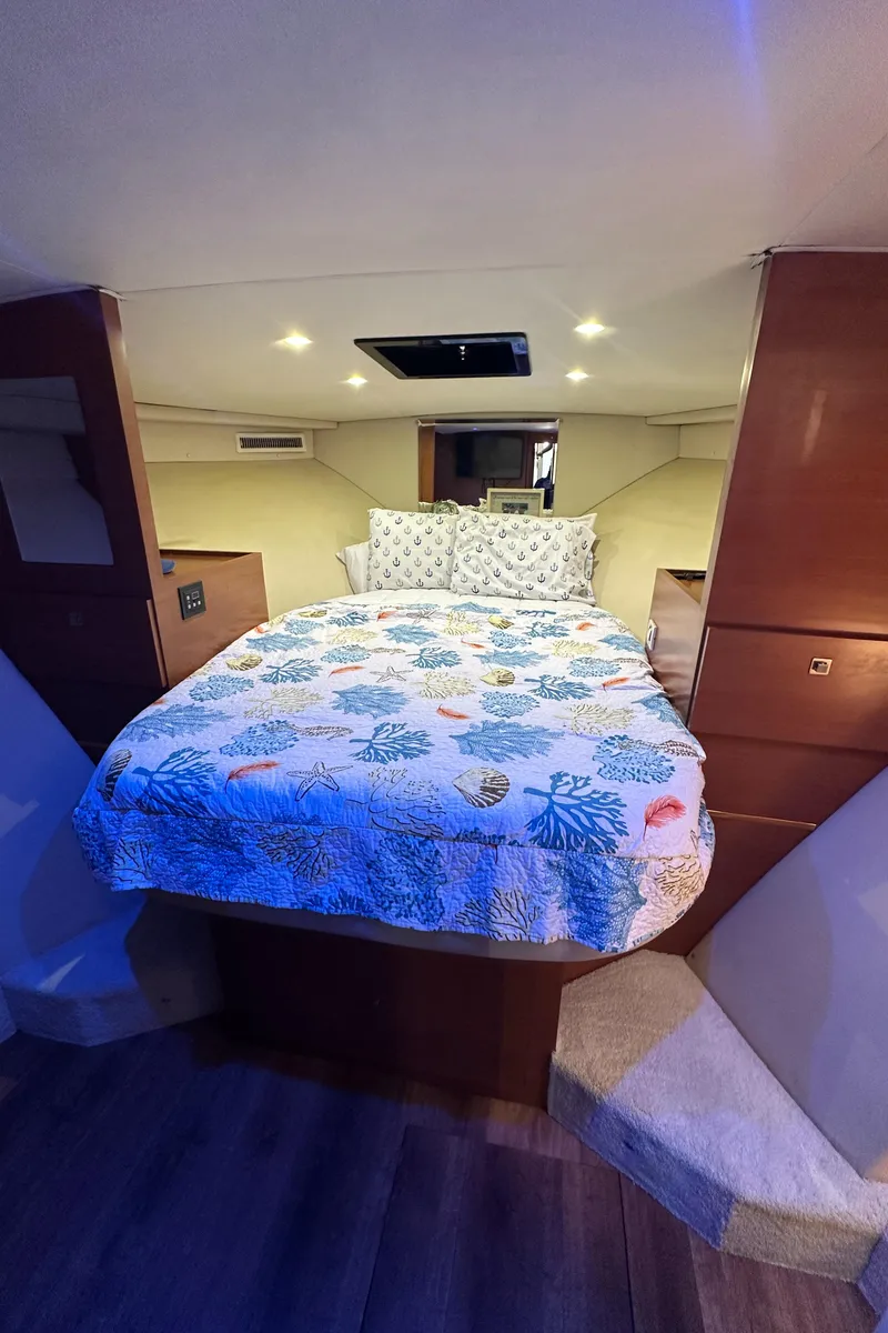Slide: The Image of Cozy bedroom in 1985 Bertram 46 Convertible yacht with floral bedding and ambient lighting. - 40