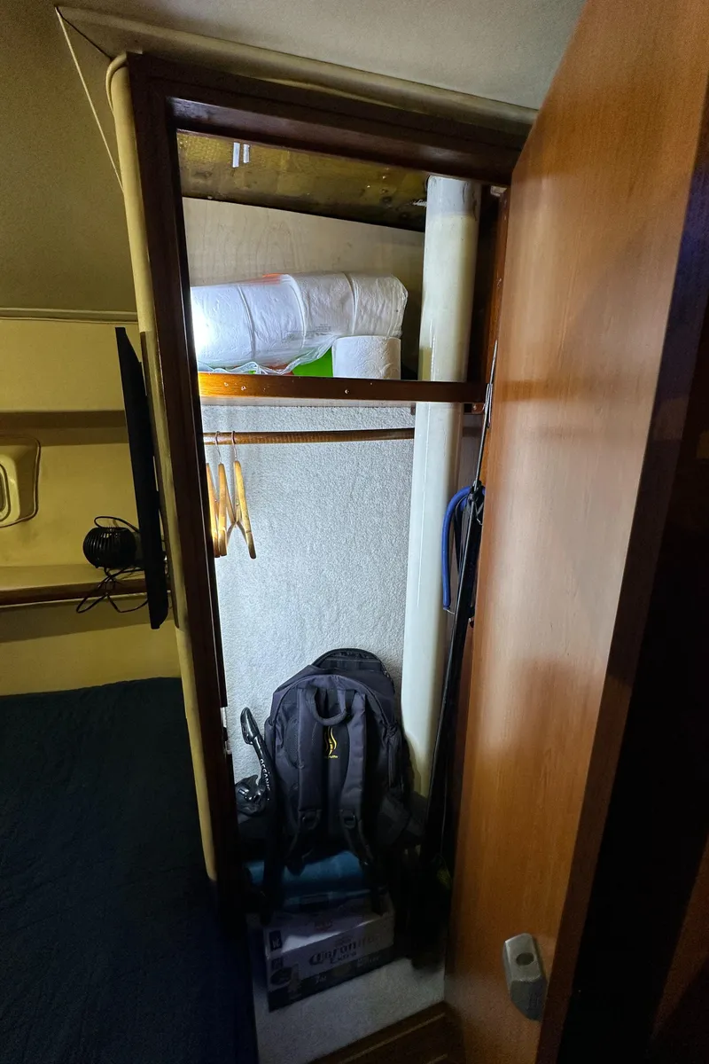 Slide: The Image of 1985 Bertram 46 Convertible interior closet with hangers, backpack, and bedding. - 42