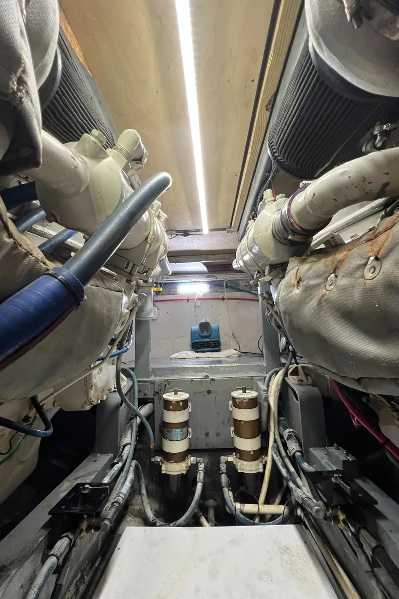 Slide: The Image of Engine room of a 1985 Bertram 46 Convertible boat, showcasing mechanical components and piping. - 45