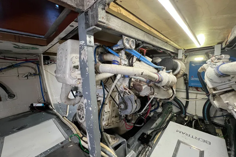 Slide: The Image of Engine room of a 1985 Bertram 46 Convertible boat, showcasing mechanical components and wiring. - 46