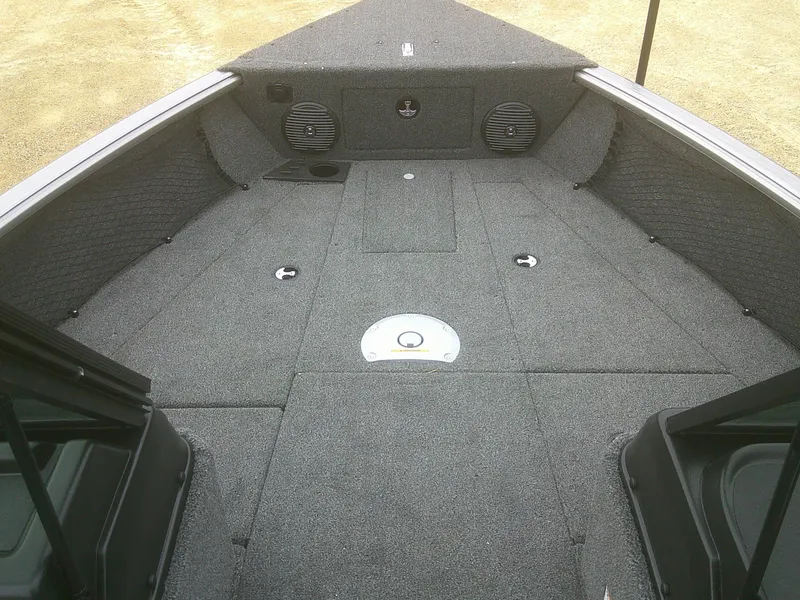 Slide: The Image of 2025 Lund 1875 Impact XS Sport boat interior with spacious, carpeted deck and storage compartments. - 11