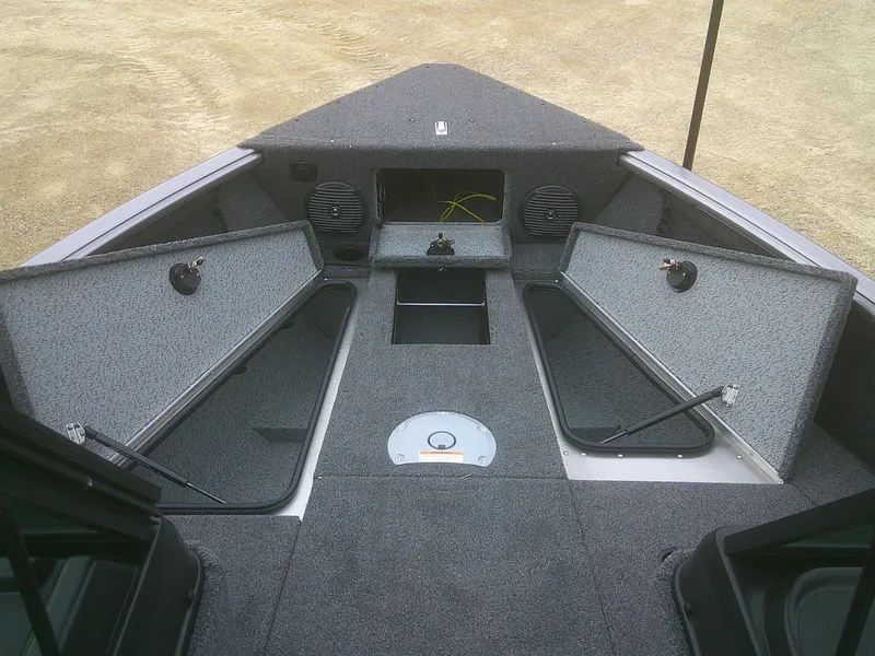 Slide: The Image of 2025 Lund 1875 Impact XS Sport boat interior with open storage compartments and speakers. - 12