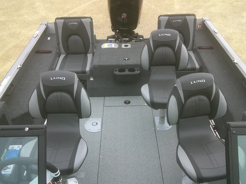 Slide: The Image of 2025 Lund 1875 Impact XS Sport boat interior with four black and gray seats. - 16