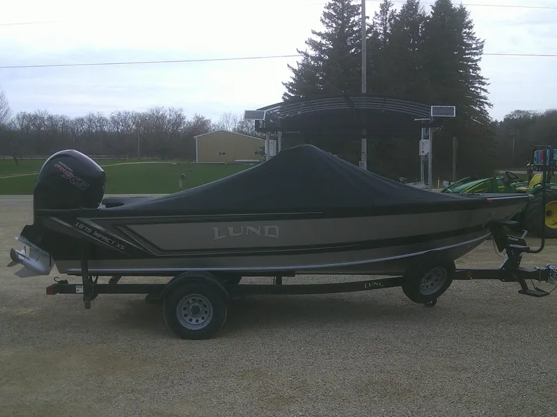 Slide: The Image of 2025 Lund 1875 Impact XS Sport boat on trailer, covered, parked outdoors. - 25
