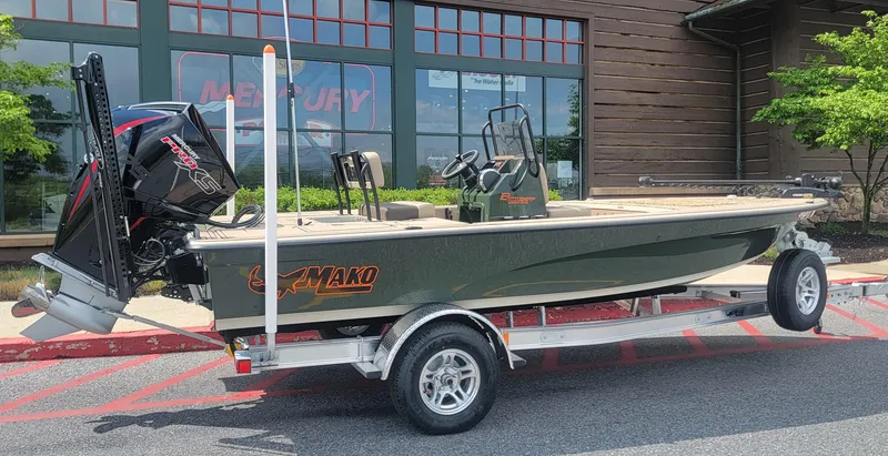 The Image of 2025 Mako 18 Pro Skiff Backwater Edition on trailer, dealership background, "We Take Trades" sign. - 0