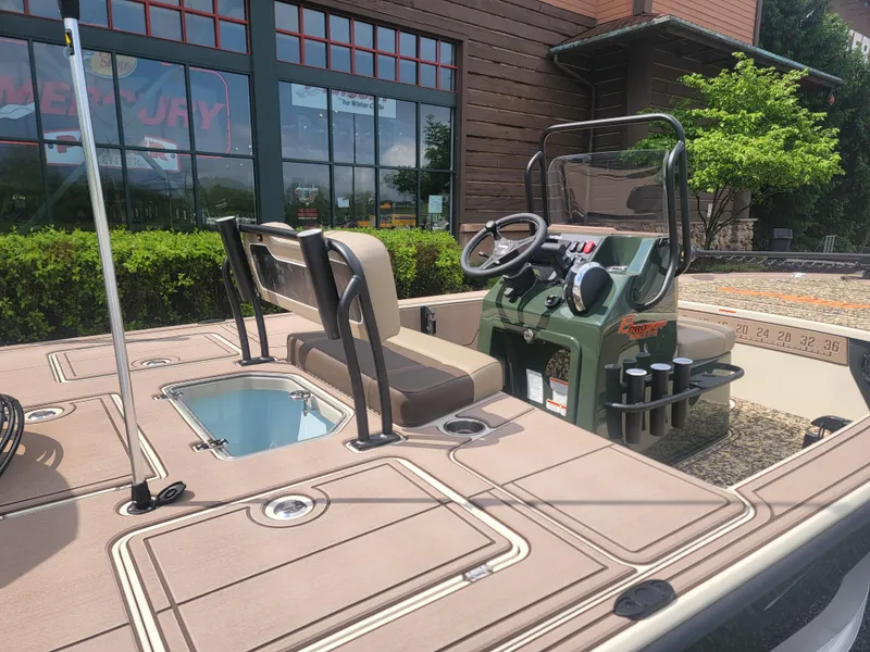 Slide: The Image of 2025 Mako 18 Pro Skiff Backwater Edition boat on trailer, parked outdoors. - 2