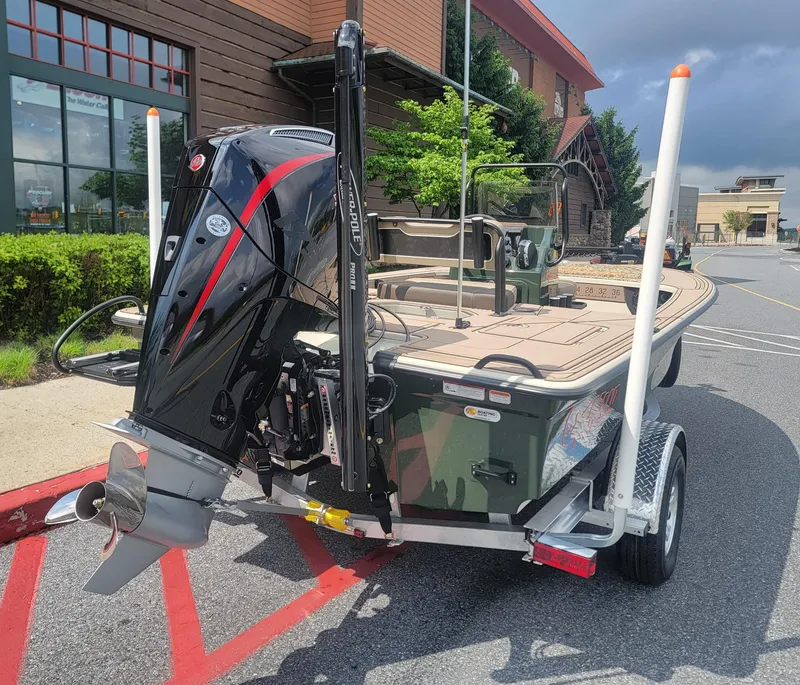 Slide: The Image of 2025 Mako 18 Pro Skiff Backwater Edition boat on trailer, featuring powerful outboard motor. - 4