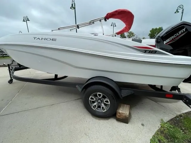 Slide: The Image of 2025 Tahoe T18 boat on trailer, white exterior, parked outdoors. - 2