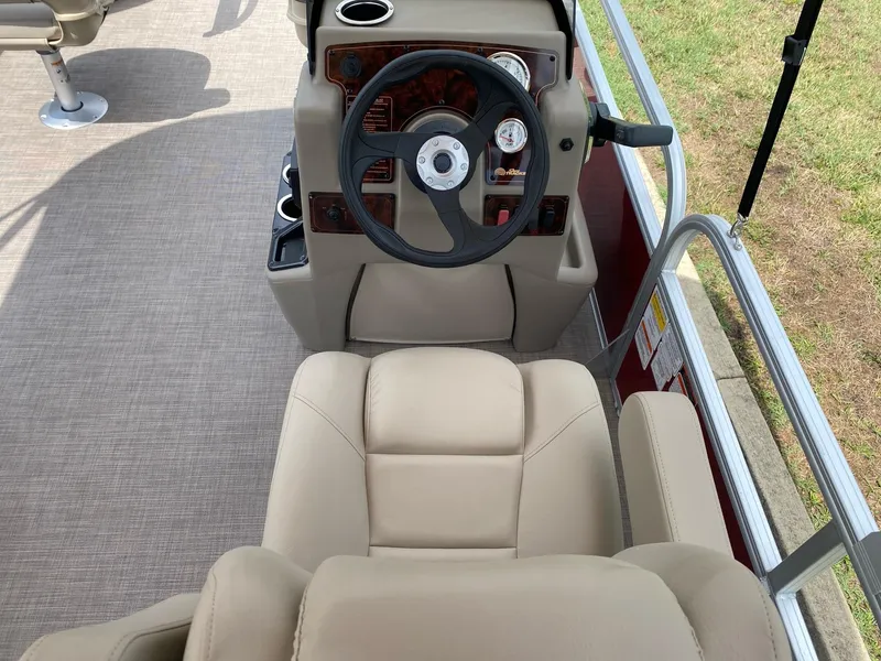 Slide: The Image of 2025 Sun Tracker Bass Buggy 18 DLX boat interior with steering wheel and beige seating. - 10