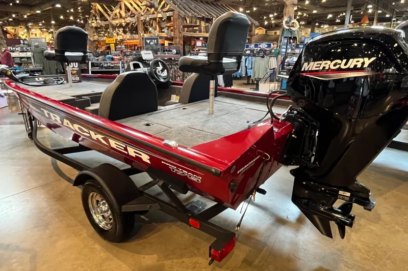 Slide: The Image of 2025 Tracker Pro Team 175 boat with Mercury engine on display indoors. - 2