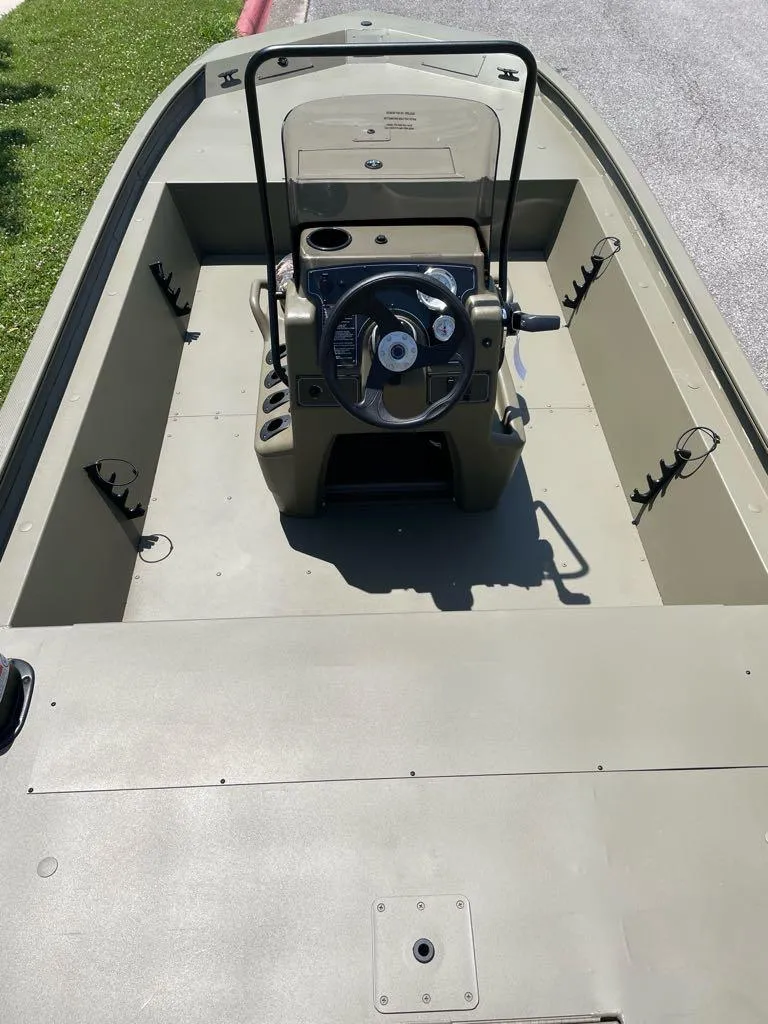 Slide: The Image of 2025 Tracker Grizzly 1860 CC boat interior with steering console and rod holders. - 4