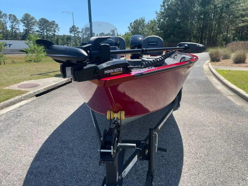 Slide: The Image of 2025 Tracker Pro Guide V-16 SC boat on trailer, red exterior, parked on a sunny road. - 4