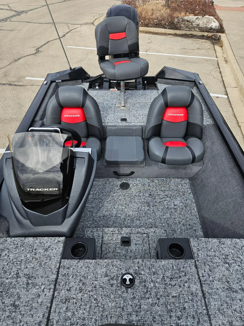 Slide: The Image of 2025 Tracker Pro Team 175 boat with gray and red seating, parked on pavement. - 2
