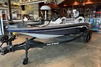 The Image of 2024 Nitro Z20 boat on display in a showroom with fishing gear. - 0
