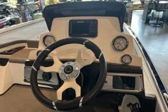 Slide: The Image of 2024 Nitro Z20 boat dashboard with steering wheel and gauges in a showroom. - 2