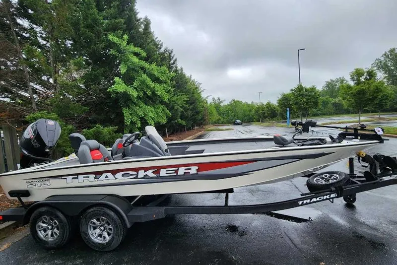 The Image of 2025 Tracker Savage 215 boat on trailer, parked in a wooded area. - 0