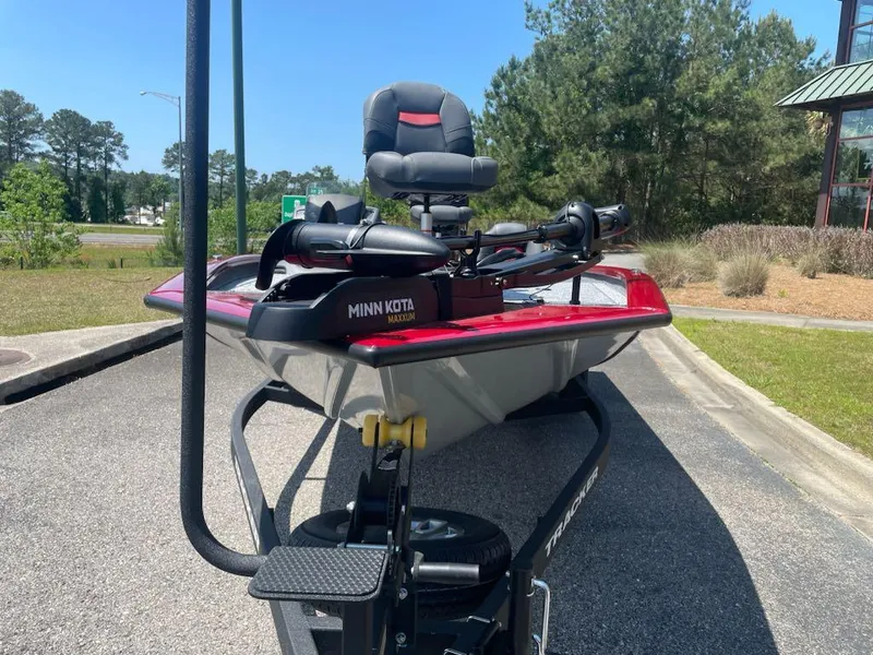 Slide: The Image of 2025 Tracker Pro Team 195 Tournament Edition boat with Minn Kota motor, parked outdoors. - 2