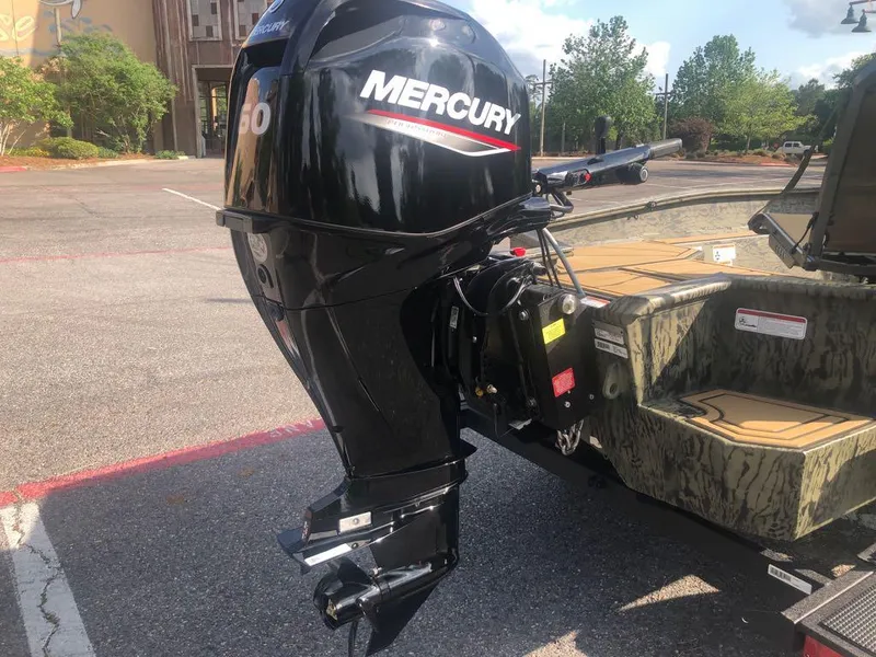 Slide: The Image of Tracker Grizzly 1650 T Prairie Wings Edition 2025 with Mercury outboard motor in parking lot. - 2
