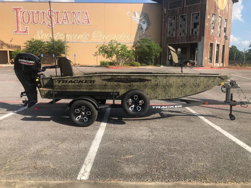 Slide: The Image of 2025 Tracker Grizzly 1650 T Prairie Wings Edition boat on trailer in parking lot. - 4