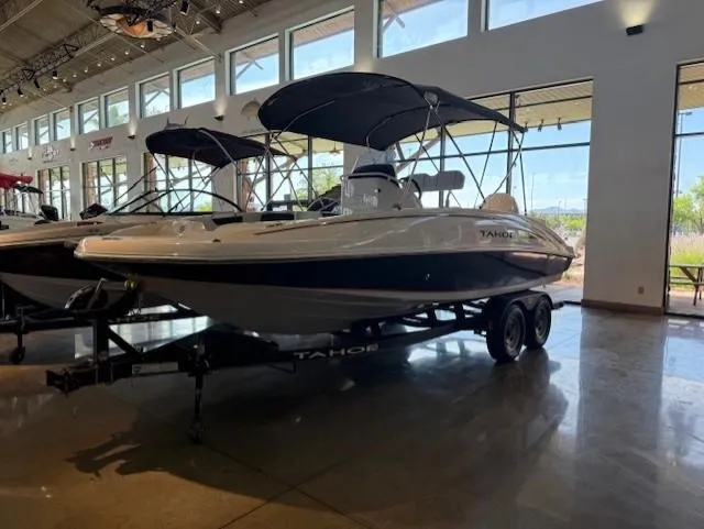 Slide: The Image of 2023 Tahoe 2150 CC boat displayed indoors on a trailer. - 0