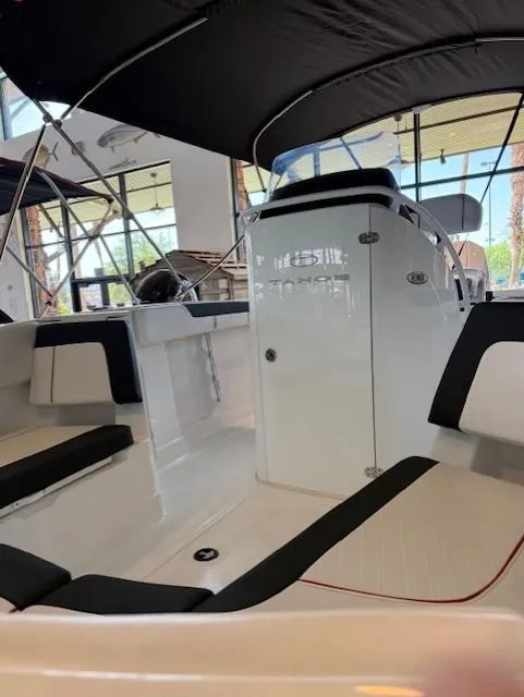 Slide: The Image of 2023 Tahoe 2150 CC boat interior with seating and console under canopy. - 6
