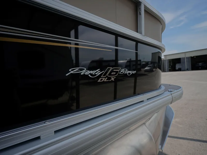 Slide: The Image of 2025 Sun Tracker Party Barge 16 DLX pontoon boat, side view with logo. - 11