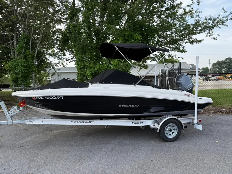 Slide: The Image of 2020 Stingray 191 DC boat on trailer, black and white design, parked outdoors. - 35
