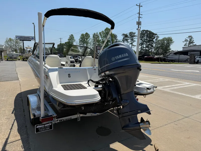 Slide: The Image of 2020 Stingray 191 DC boat with Yamaha outboard motor on a trailer, parked outdoors. - 5