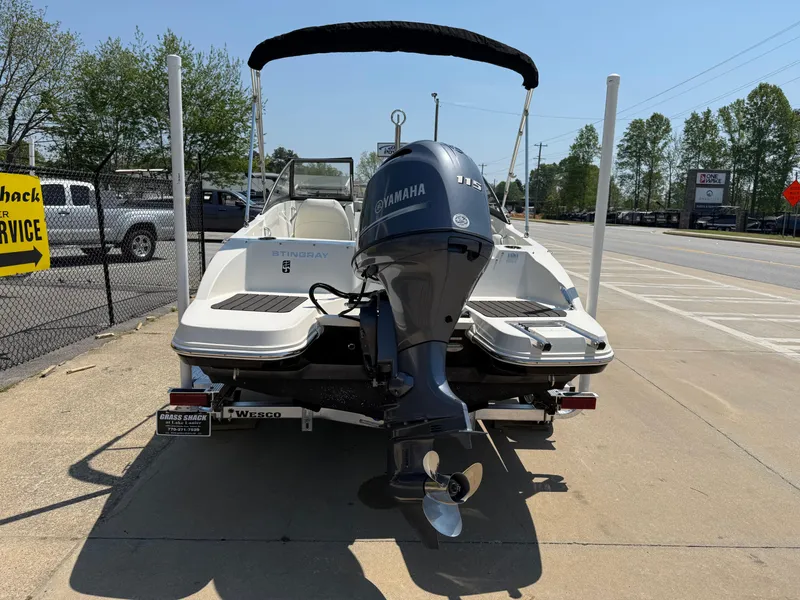 Slide: The Image of 2020 Stingray 191 DC boat with Yamaha outboard motor, parked on a sunny day. - 6