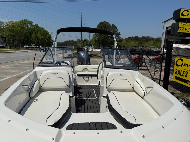 Slide: The Image of 2020 Stingray 191 DC boat with dual consoles and seating, displayed outdoors at a sales lot. - 7