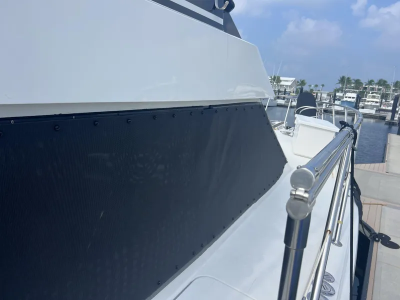 Slide: The Image of 1995 Hatteras 52 Motor Yacht docked, showcasing sleek design and polished railings. - 110