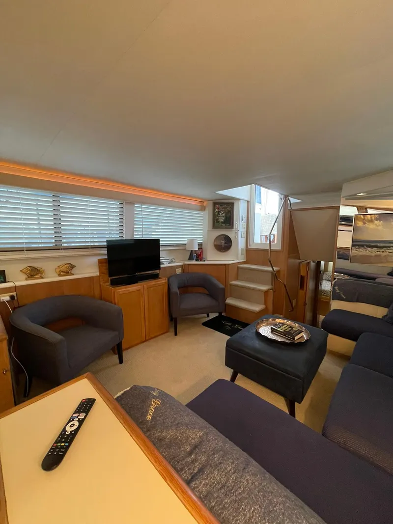 Slide: The Image of Interior of 1995 Hatteras 52 Motor Yacht, featuring cozy seating and modern amenities. - 16