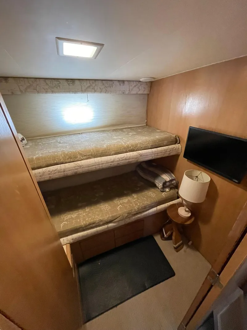 Slide: The Image of Interior of 1995 Hatteras 52 Motor Yacht with bunk beds and a small lamp. - 47