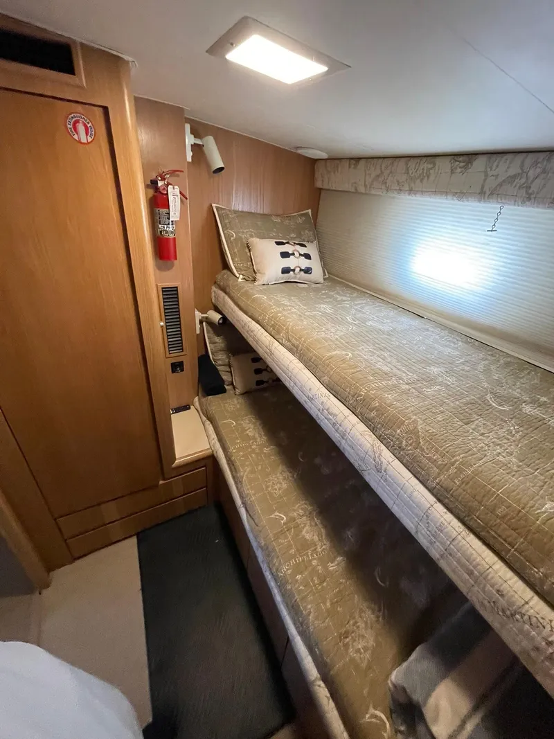 Slide: The Image of Interior of 1995 Hatteras 52 Motor Yacht with cozy bunk beds and wooden paneling. - 48