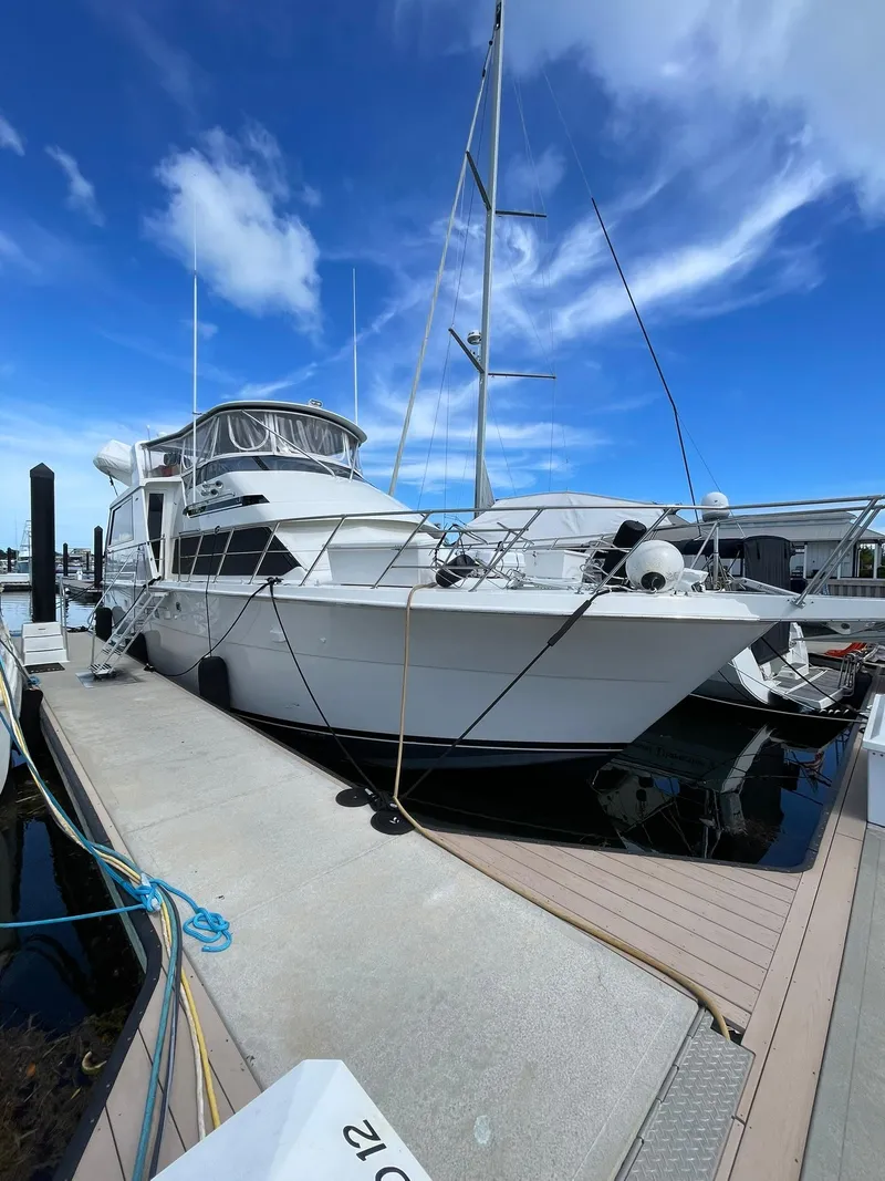 Slide: The Image of 1995 Hatteras 52 Motor Yacht docked under a clear blue sky. - 5