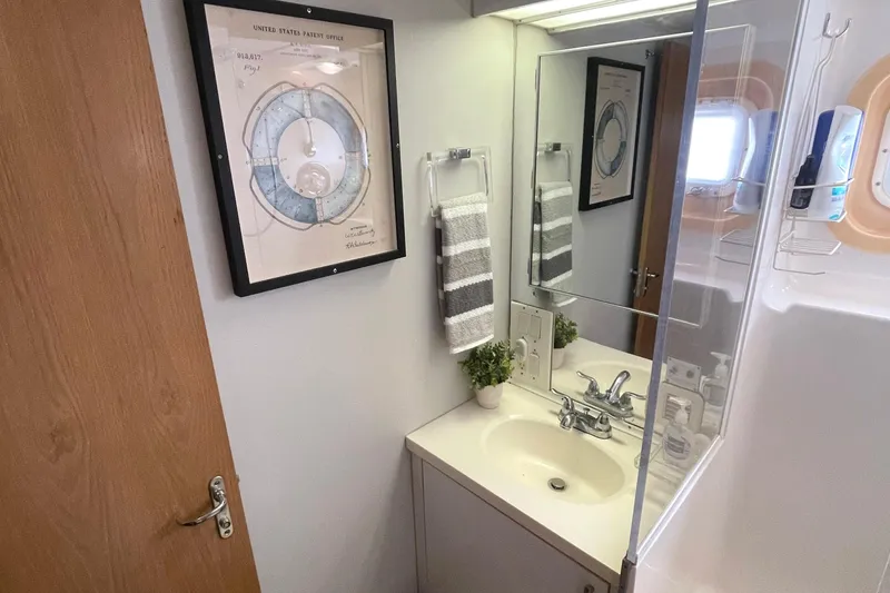 Slide: The Image of Bathroom interior of 1995 Hatteras 52 Motor Yacht with sink, mirror, and framed artwork. - 50
