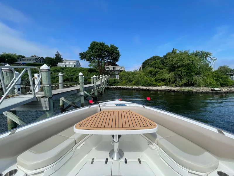 Slide: The Image of 2017 Boston Whaler 420 Outrage boat docked, featuring a wooden table and scenic waterfront view. - 16