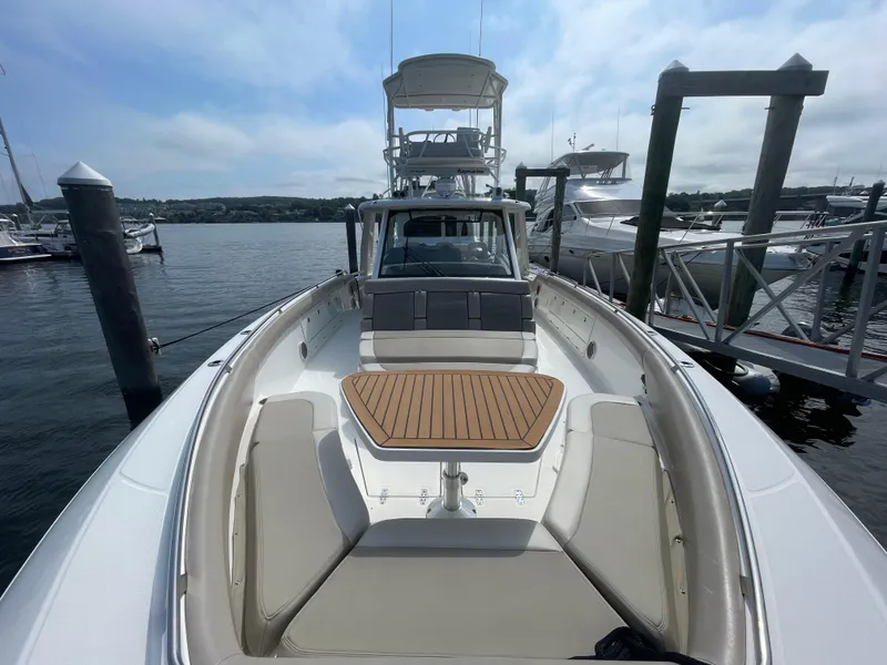 Slide: The Image of 2017 Boston Whaler 420 Outrage docked, showcasing spacious deck and seating area. - 17