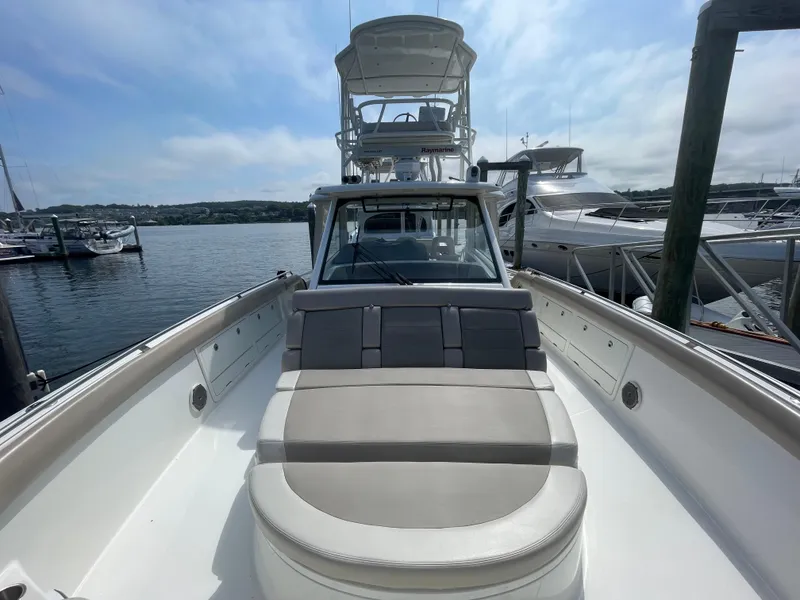Slide: The Image of 2017 Boston Whaler 420 Outrage boat docked at marina, featuring spacious seating and clear skies. - 18