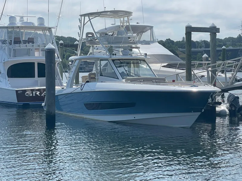 Slide: The Image of 2017 Boston Whaler 420 Outrage docked at marina, surrounded by other boats. - 2