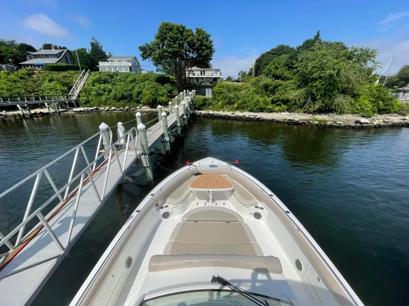 Slide: The Image of 2017 Boston Whaler 420 Outrage docked by a scenic waterfront with lush greenery. - 22